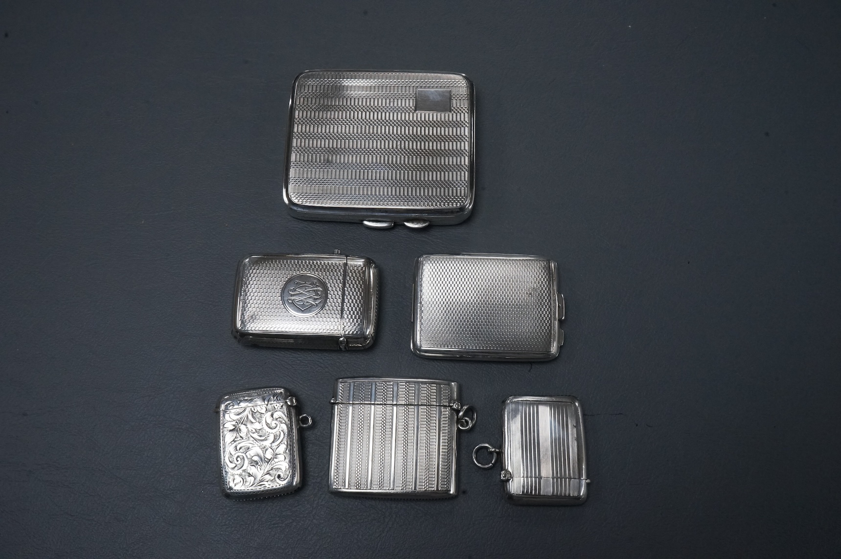 Four assorted early 20th century silver vesta cases including one with a stamp compartment, containing a penny red, maker William Light, Birmingham, 1906, 42mm, together with a silver cigarette case and a silver match sl